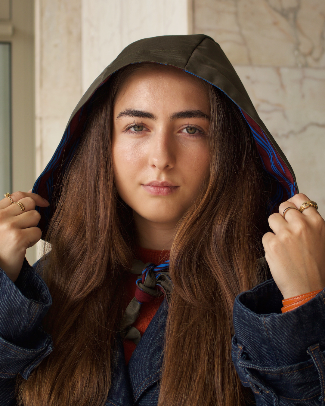 Femme portant une capuche à nouer réversible et imperméable kaki à rayures bordeaux KOON